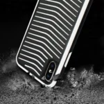 Close-up of a rugged phone case resisting impact on a dark surface.
