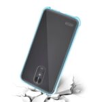 Smartphone with a blue protective case falling onto a cracked surface.