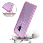 A pink protective phone case with a built-in ring stand on a cracked surface.