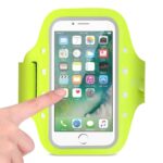 Hand interacting with a smartphone in a neon green armband case.