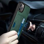 A phone with a green case is mounted on a car vent using a magnetic holder.
