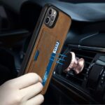 A hand holding a phone case with a card slot and a magnetic car mount attachment.