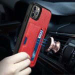 A hand holding a red phone case with a strap, near a car's dashboard.