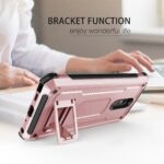 A person using a pink phone case with a foldable stand on a desk.