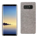 Samsung smartphone with a fabric-textured case beside it.