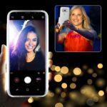 Woman taking a selfie with a smartphone, smiling brightly.
