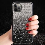 Hand holding a glittery, star-patterned phone case with red nail polish.
