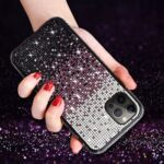 Glamorous phone case with sparkling rhinestones and red manicured nails.