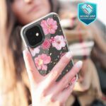 Person holding a smartphone with a floral patterned case.
