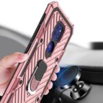 Close-up of a hand holding a pink rugged phone case with a ring holder.