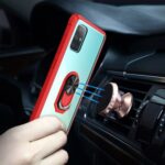 A hand placing a red phone holder on a car air vent.