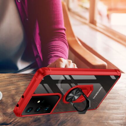 Person holding a red smartphone with a ring holder attached.
