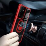 A hand holding a red and black phone case with a ring holder inside a car.