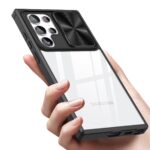 Hand holding a smartphone with a protective case and camera lens cover.