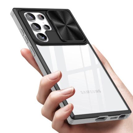 Hand holding a phone with a black lens protector on the camera area.