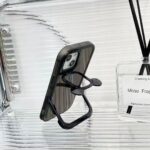 Black phone case with a built-in kickstand on a glass surface.