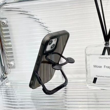 Black phone case with a built-in kickstand on a glass surface.