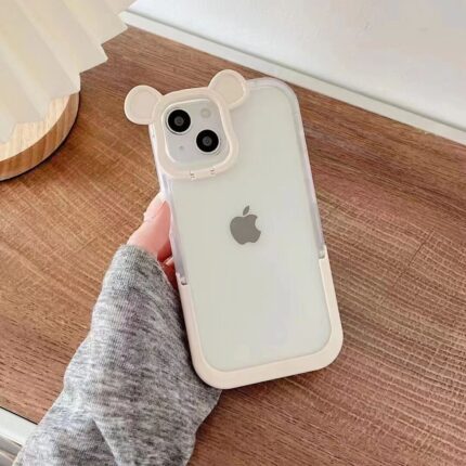 Clear iPhone case with bear ears held against wooden background.